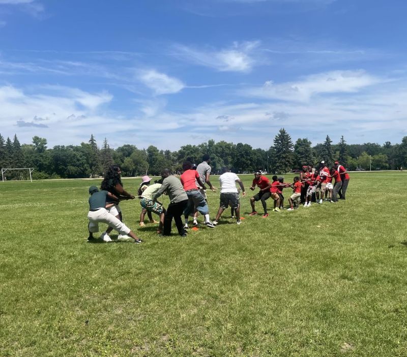 people in a game of tug of war on an open field